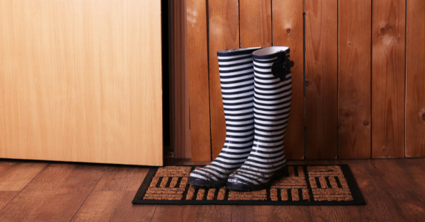 Dirty wellington boots on the door mat in the room