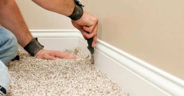 Installer Using Carpet Knife to Tuck New Floor