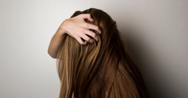 Photo of a woman covering her face with her hair.